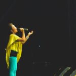 woman holding a microphone performing on stage