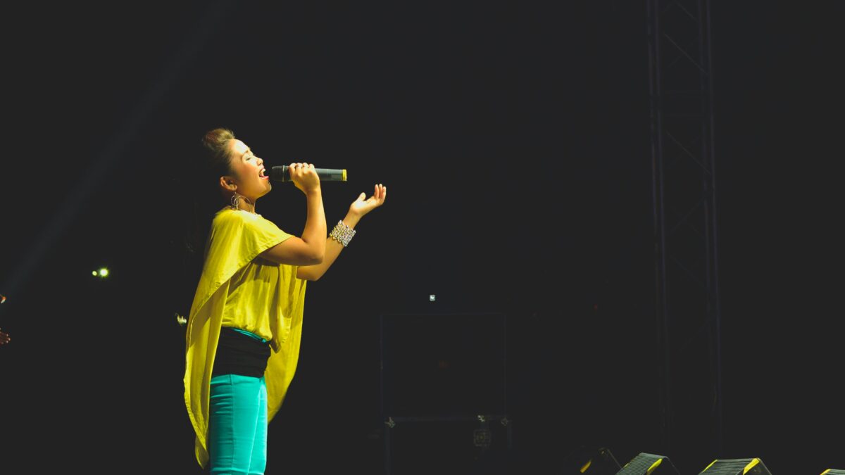 woman holding a microphone performing on stage
