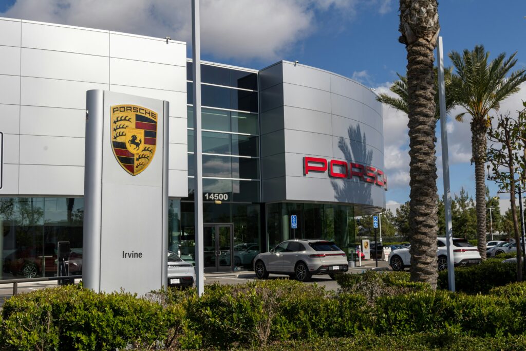 Current image: a porsche dealership with cars parked in front of it