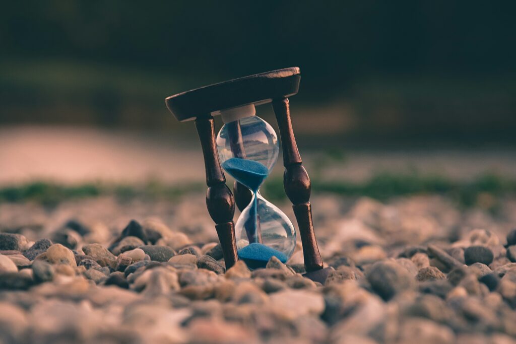 Current image: selective focus photo of brown and blue hourglass on stones